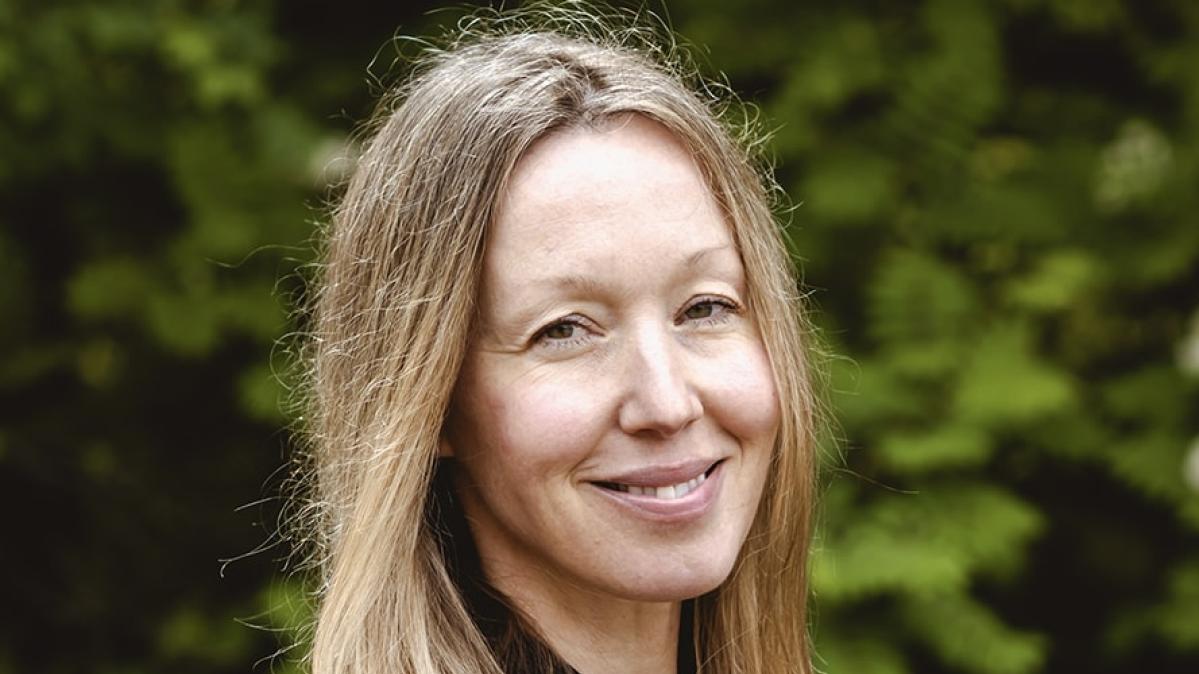 New Vice-Principal of Mount Sentinel Secondary, Emily Mather A woman with dark blonde long hair wearing a black shirt smiles in front of a green bush outdoors.